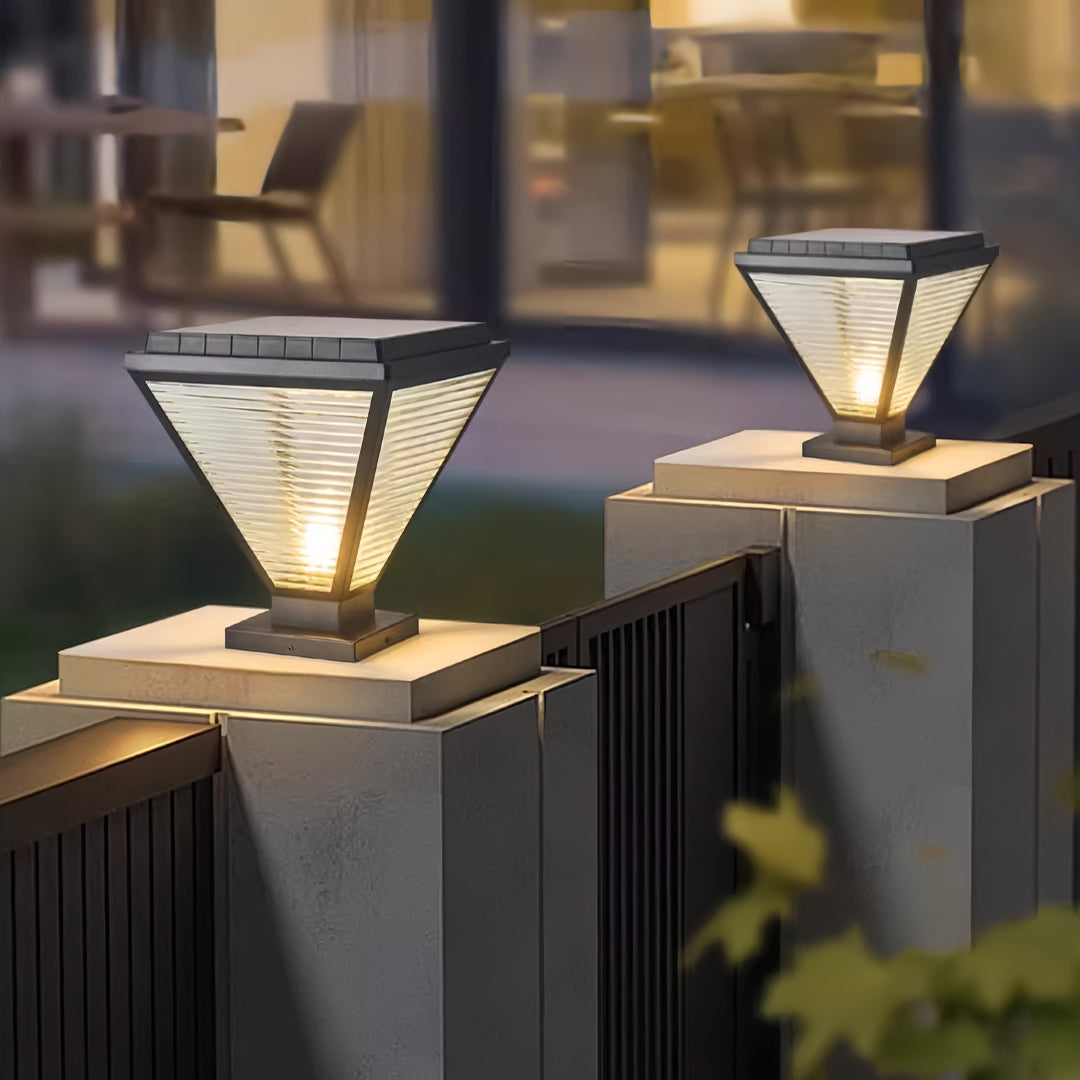 Outdoor pillar lights led installed along a modern fence at dusk.