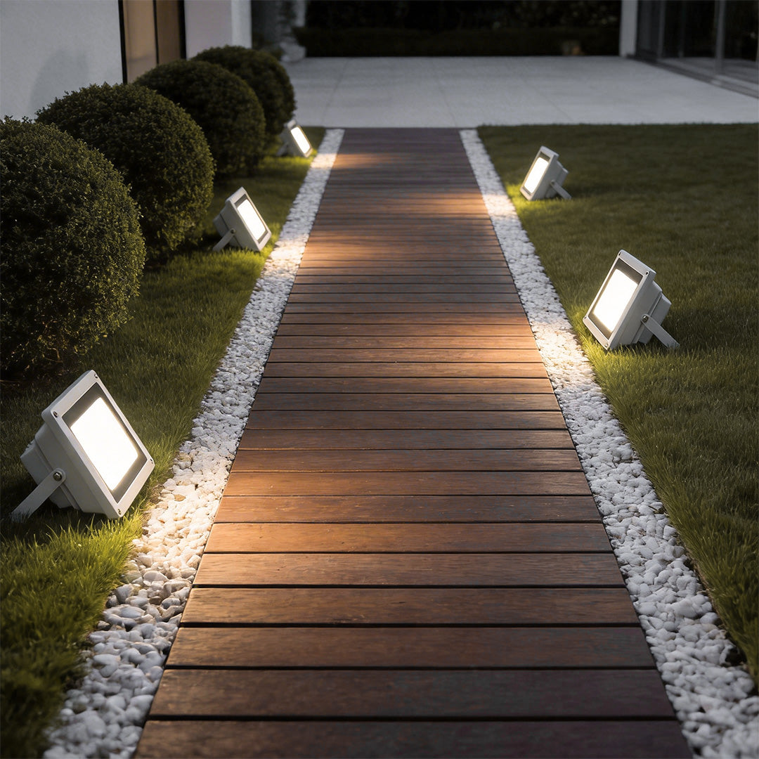 Outdoor flood lights LED with a sleek design, lighting up a wooden walkway.
