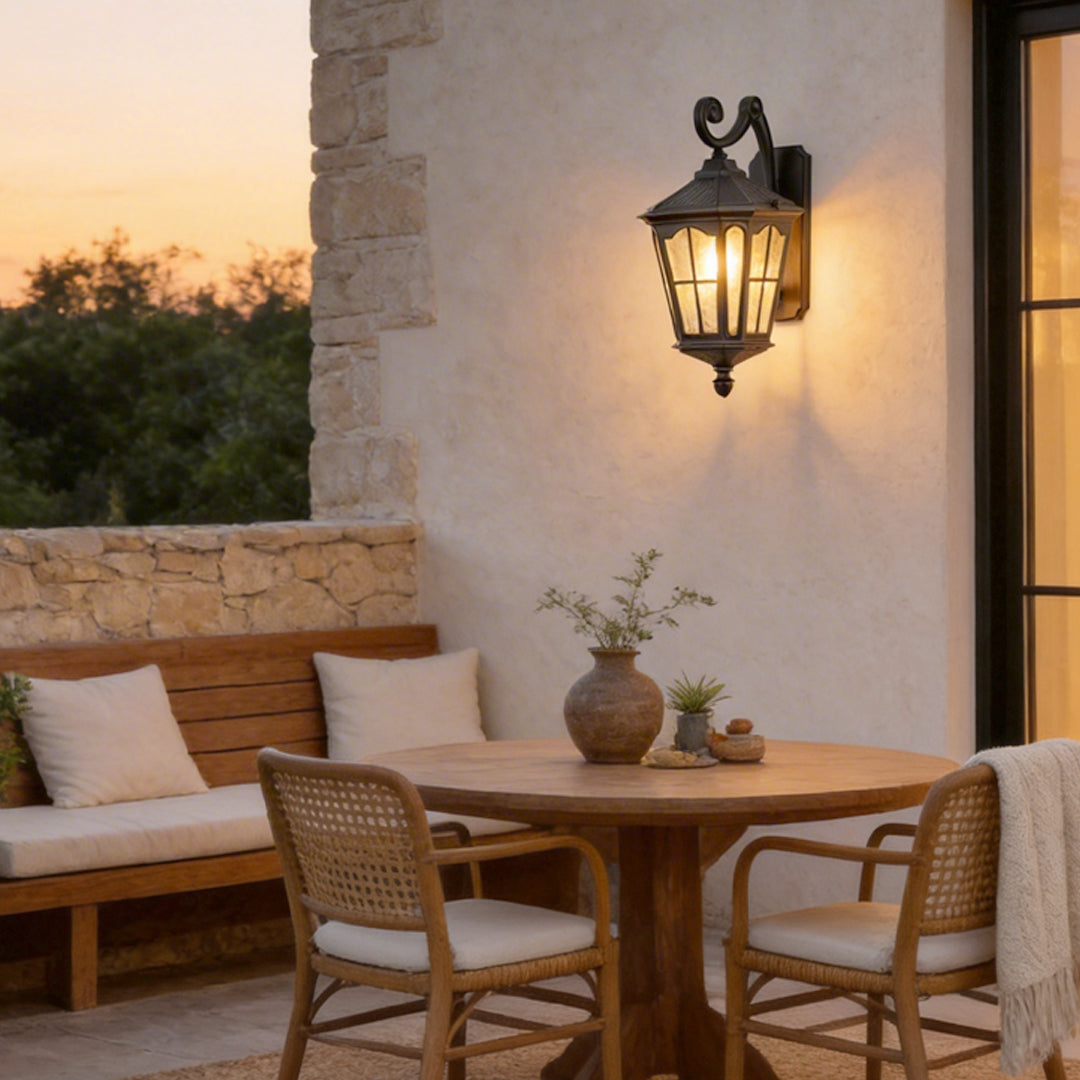 Outdoor front porch lights with a classic design, illuminating a cozy dining area on a patio.