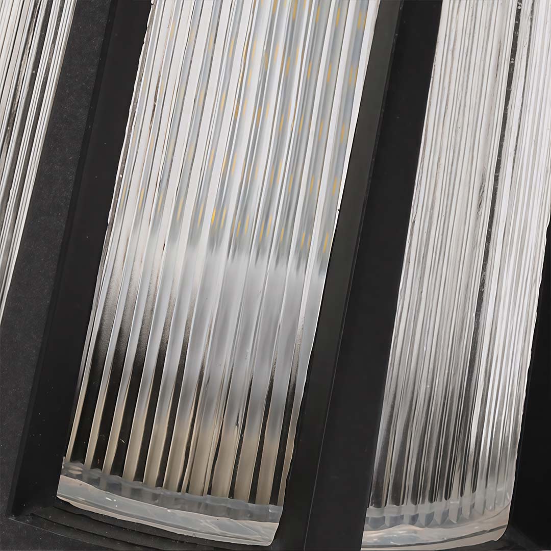 Outdoor garden path lamp with a close-up of its illuminated ribbed glass and base.