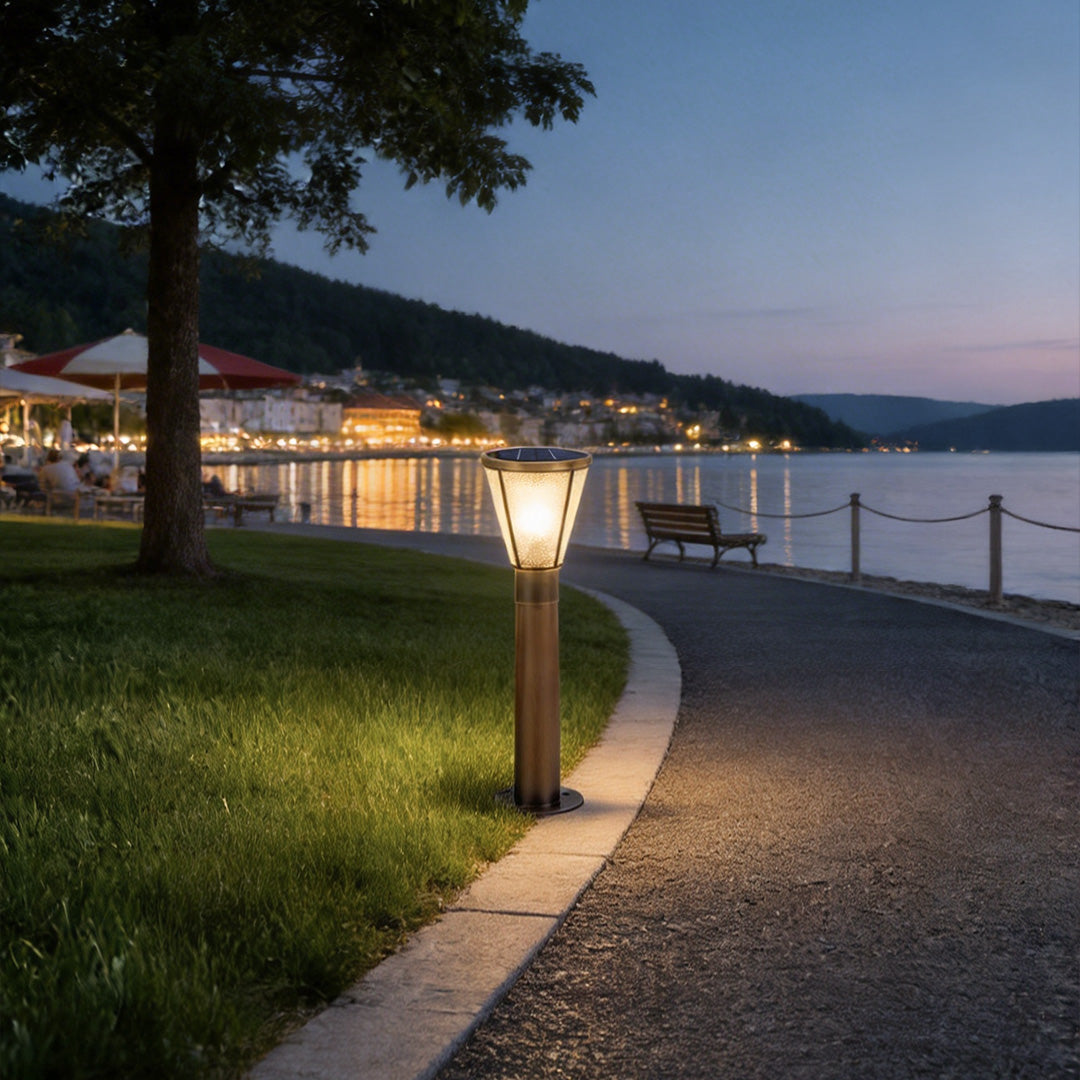 Outdoor garden path lights with a sleek design, lighting up a curved walkway near a lake.