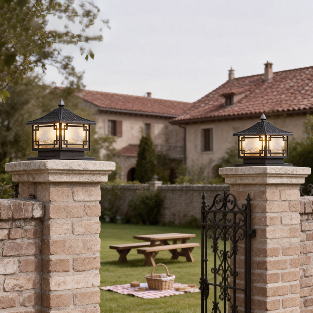 Outdoor garden pillar lights mounted on brick pillars, enhancing the pathway to a garden with warm light.