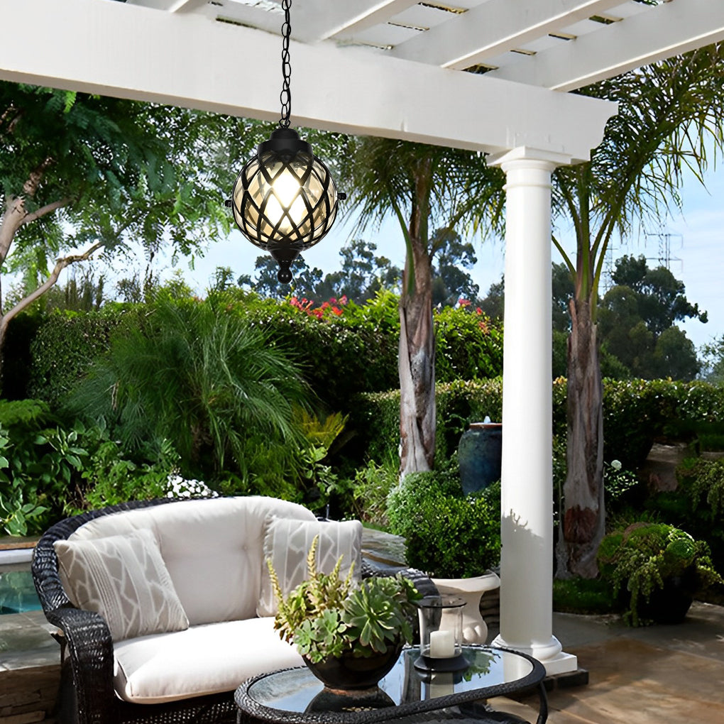 Outdoor globe pendant light hanging from pergola, illuminating a cozy patio seating area.