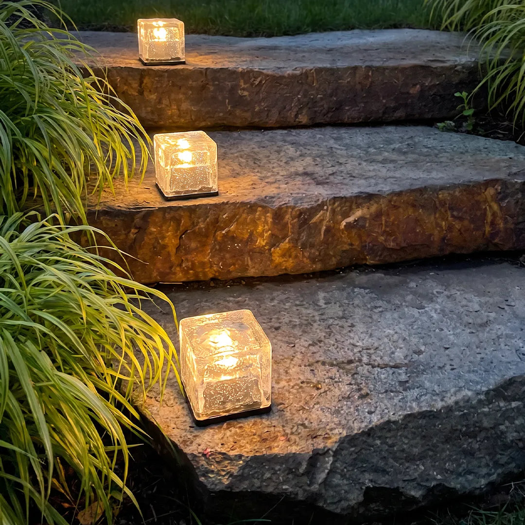 Outdoor ice cube lights arranged on natural stone steps, creating soft ambient lighting for the landscape.