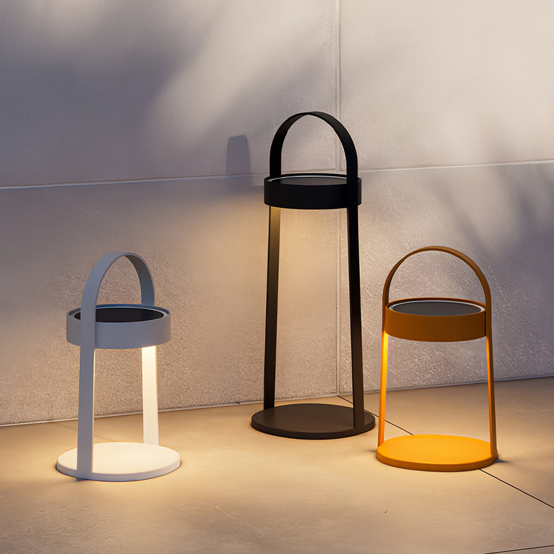 Group of outdoor landscaping lighting lanterns arranged on outdoor seating area at night.