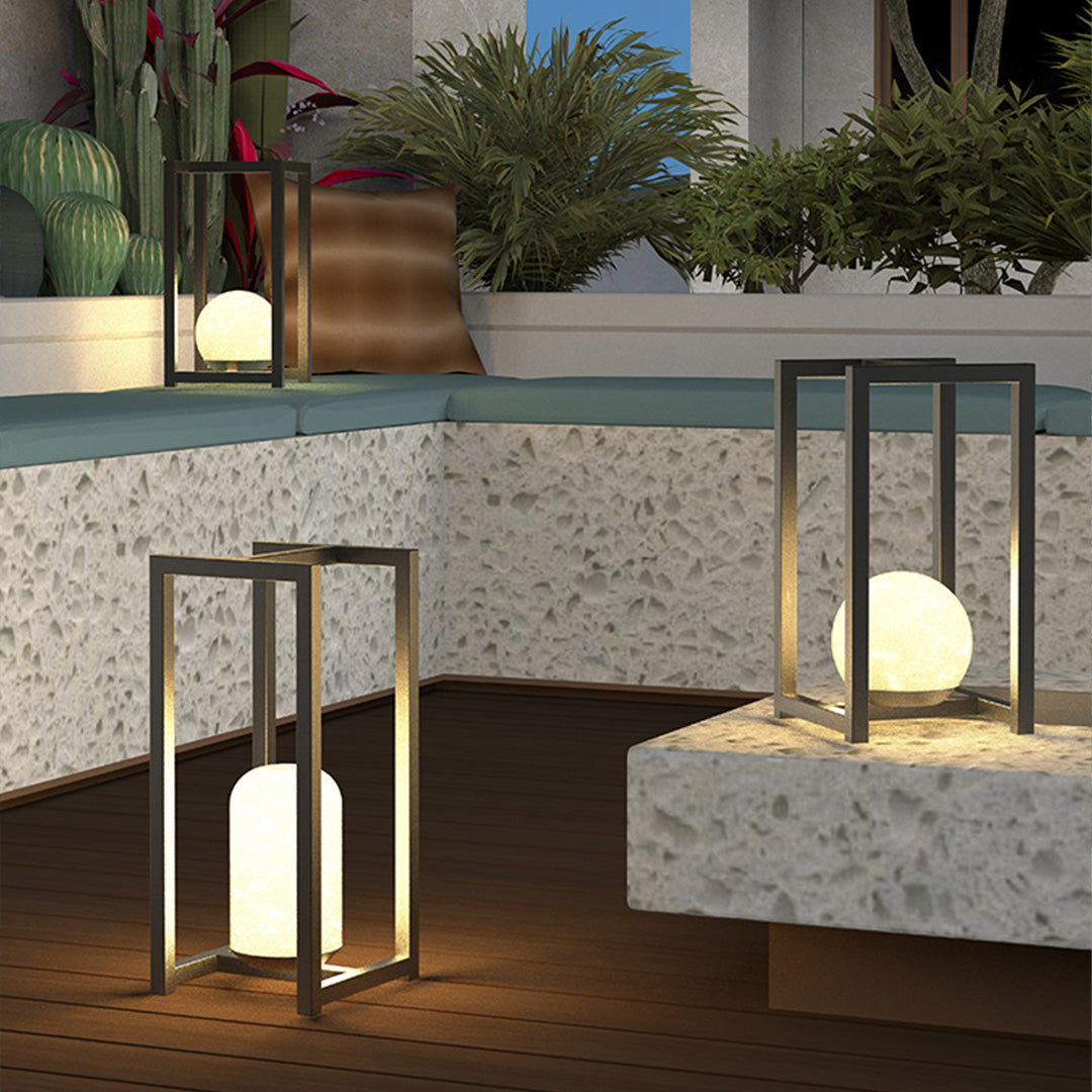 Black outdoor lanterns black displayed on a patio step, creating warm decorative ambient lighting.