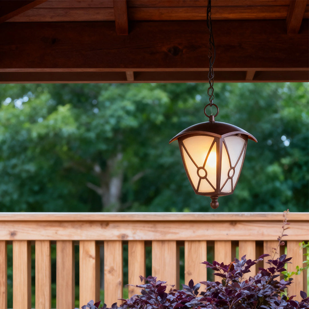Outdoor LED pendant light glowing warmly under covered deck with wooden railing and purple flowers