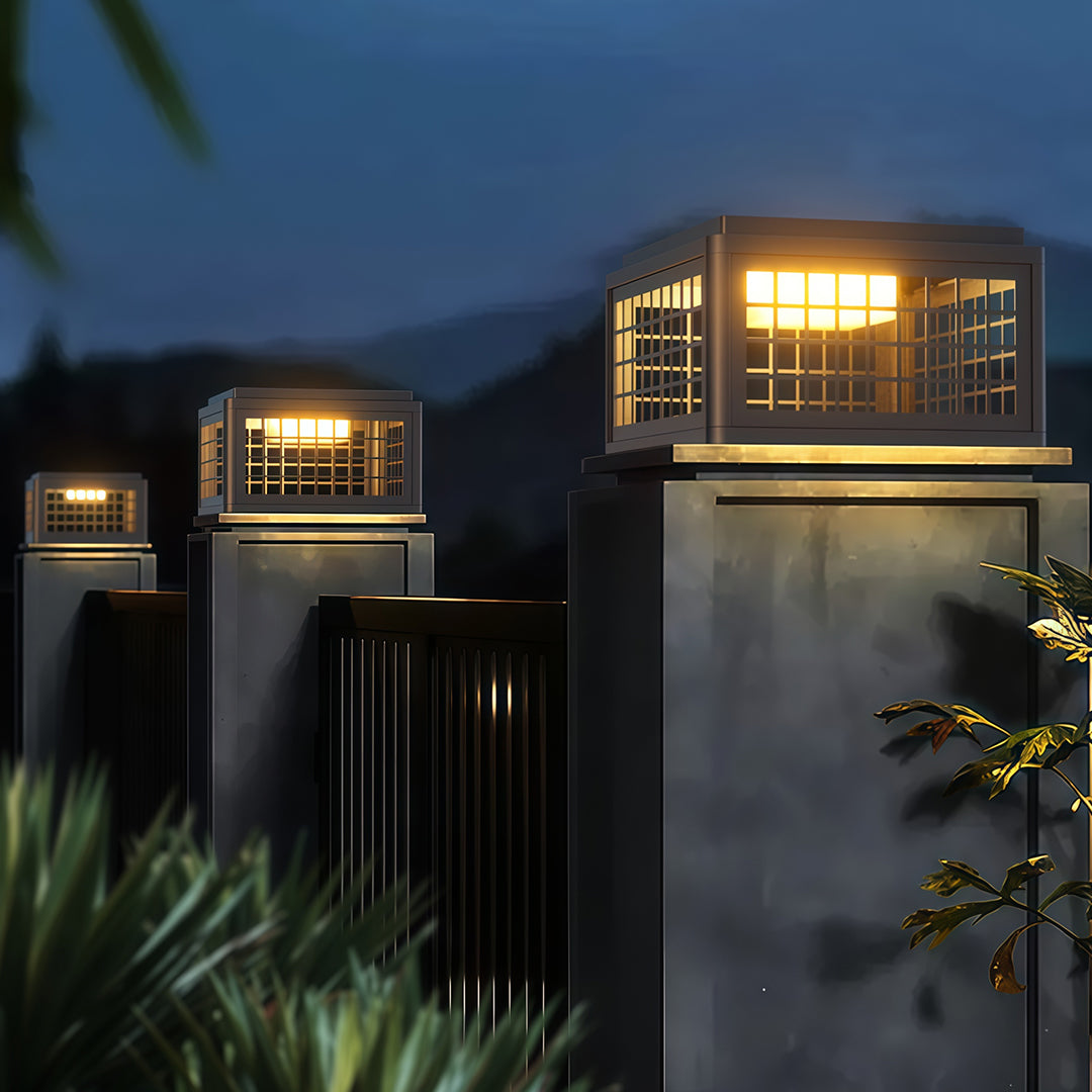 Outdoor LED pillar light along a pathway near a modern house, offering stylish and functional lighting.