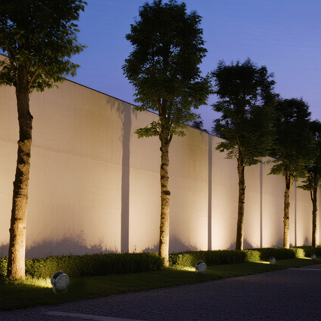 Outdoor lighting LED spotlights illuminating modern residential fence with dramatic uplighting effect