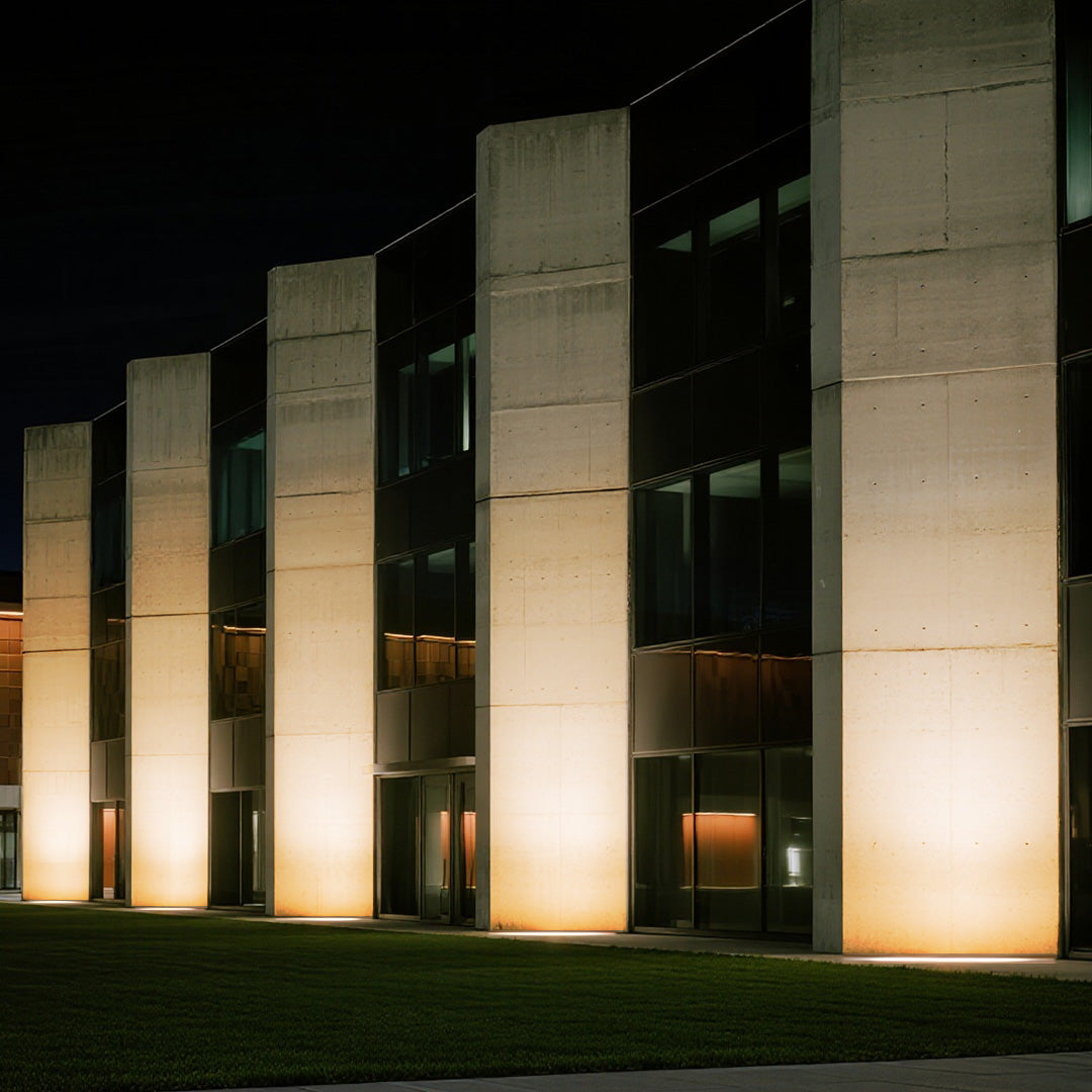 Modern building exterior featuring outdoor LED wall wash lighting with clean vertical illumination columns