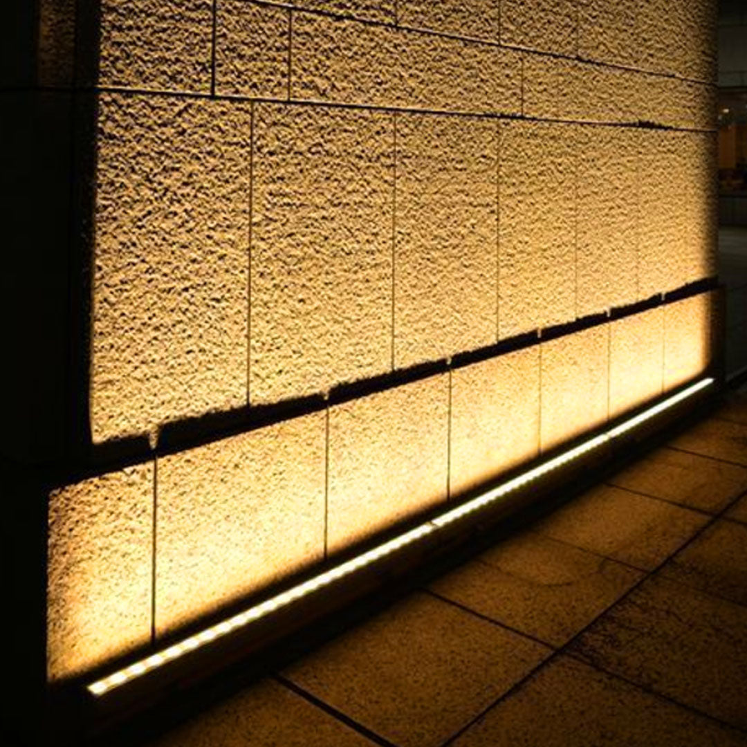 Outdoor LED wall wash lighting system providing uniform warm illumination across concrete architectural surface