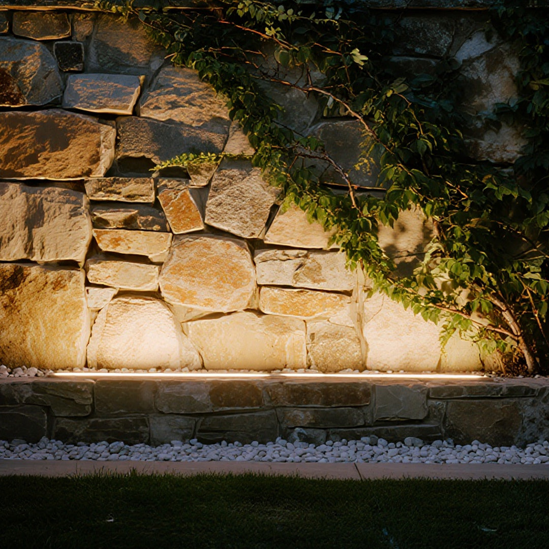 Outdoor LED wall wash lighting illuminating natural stone wall with warm ambient landscape lighting effect