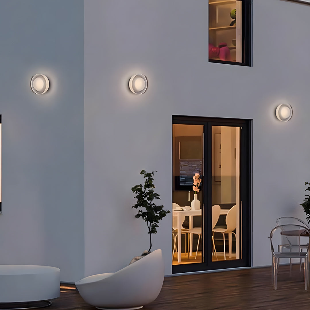 Cluster of outdoor light fixtures wall installed on a white exterior façade creating warm decorative lighting.