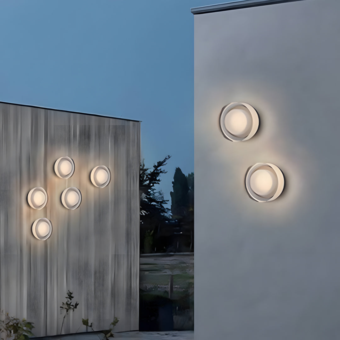 Two outdoor light fixtures wall mounted on a wooden exterior wall providing soft round illumination.