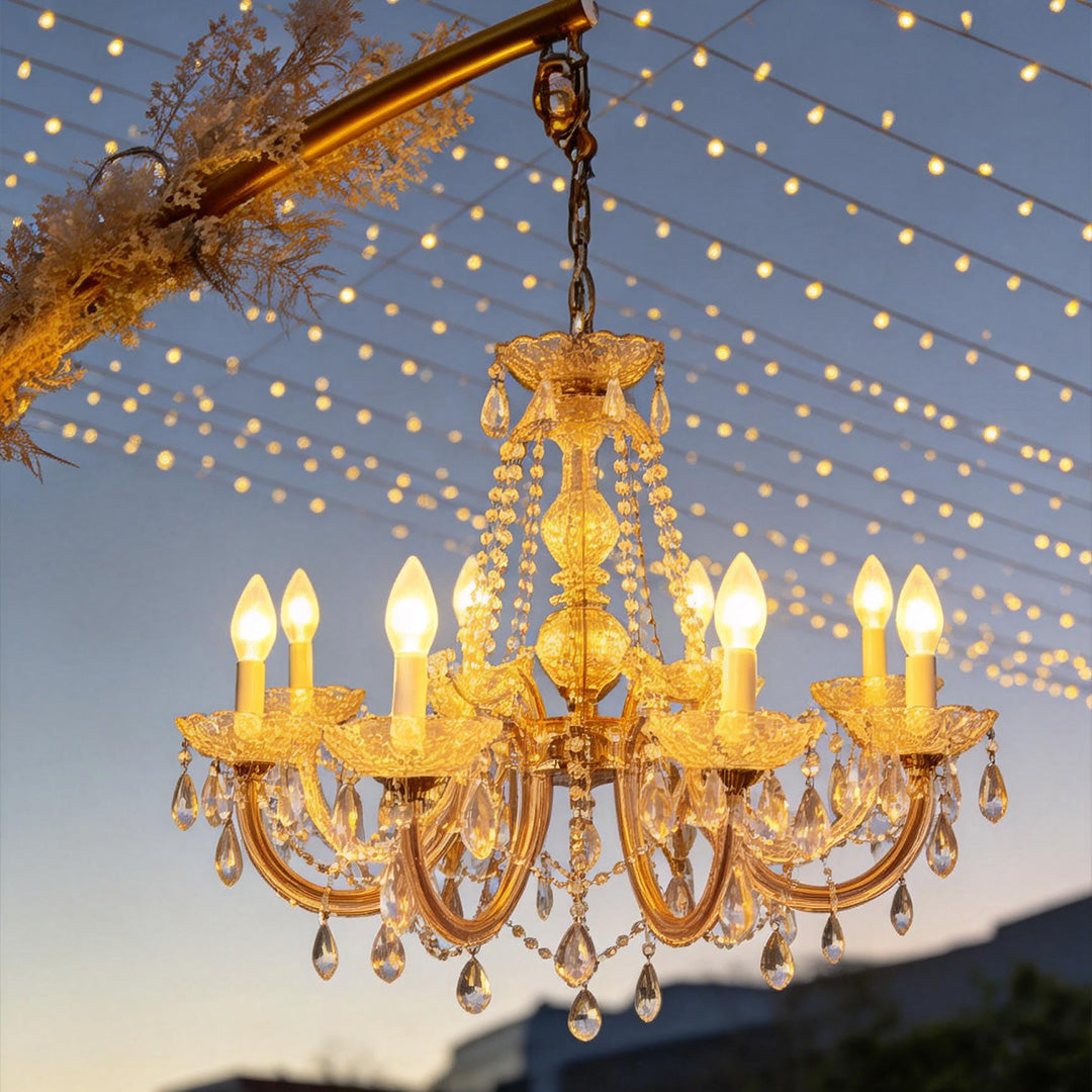 Outdoor lighting hanging with crystal details, illuminating a garden archway at dusk.