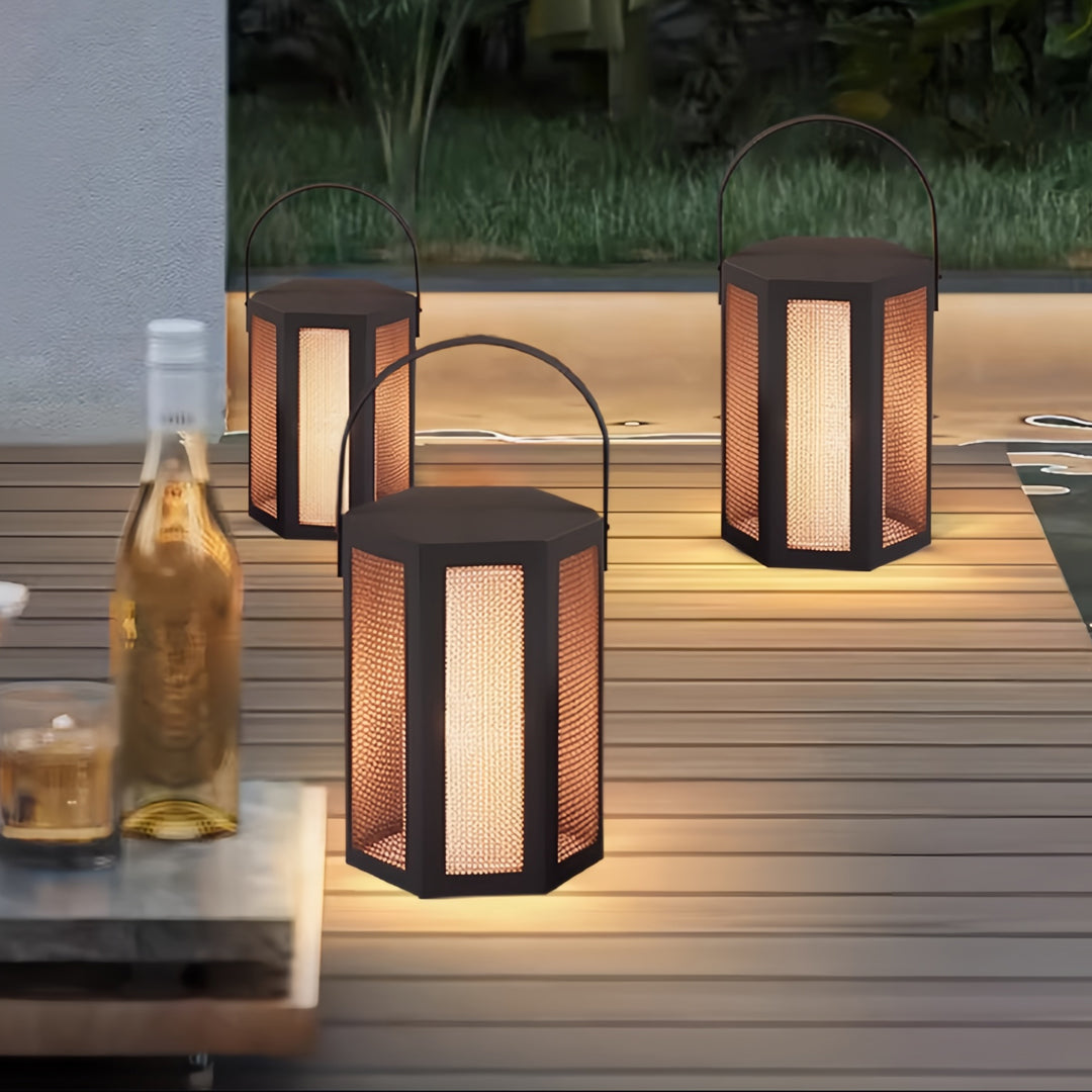 Outdoor lighting lanterns arranged beside a wooden deck, providing warm ambient lighting for outdoor relaxation.