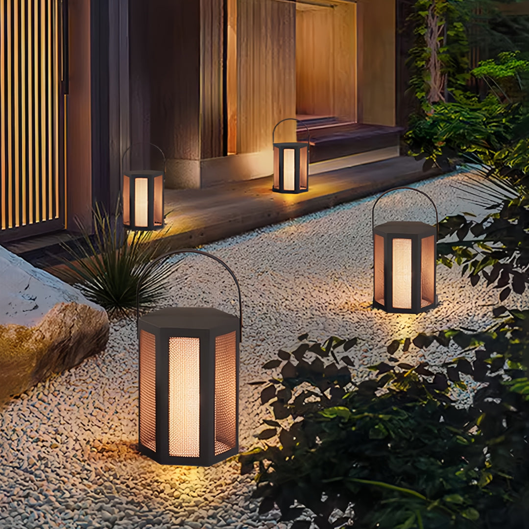 Outdoor lighting lanterns placed along a modern garden walkway, creating inviting ambient illumination.