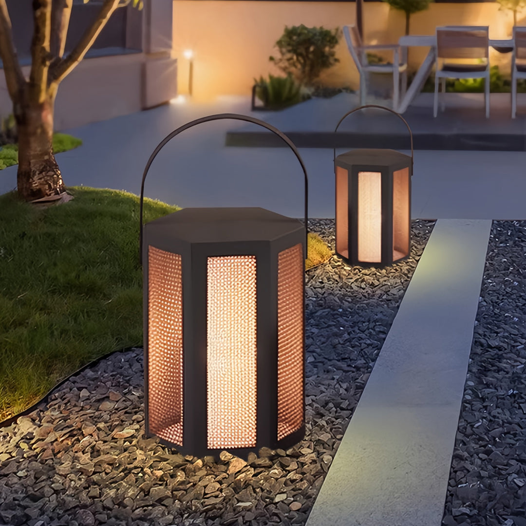Close-up view of outdoor lighting lanterns lighting a stone walkway with warm decorative glow.