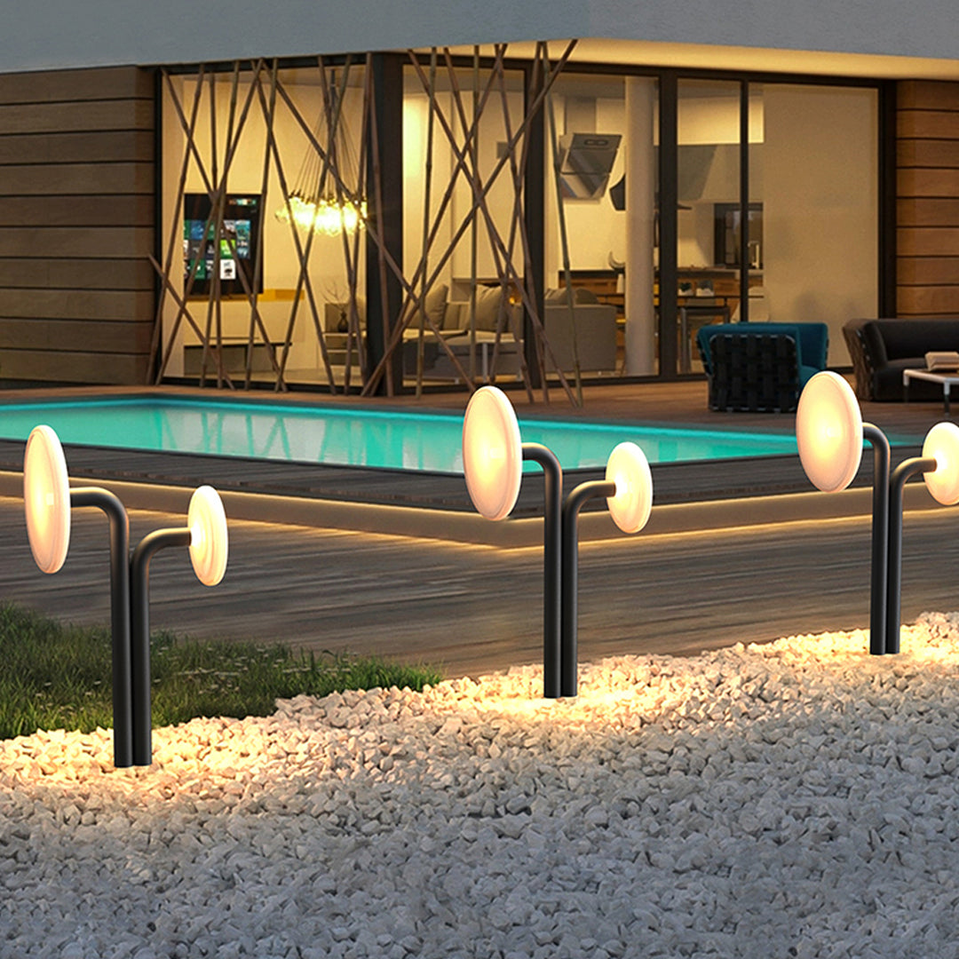 Outdoor lighting path lights arranged around a patio space with warm illumination at night.