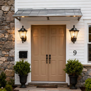 Pair of outdoor lights for wall flanking wooden double doors on modern home entrance