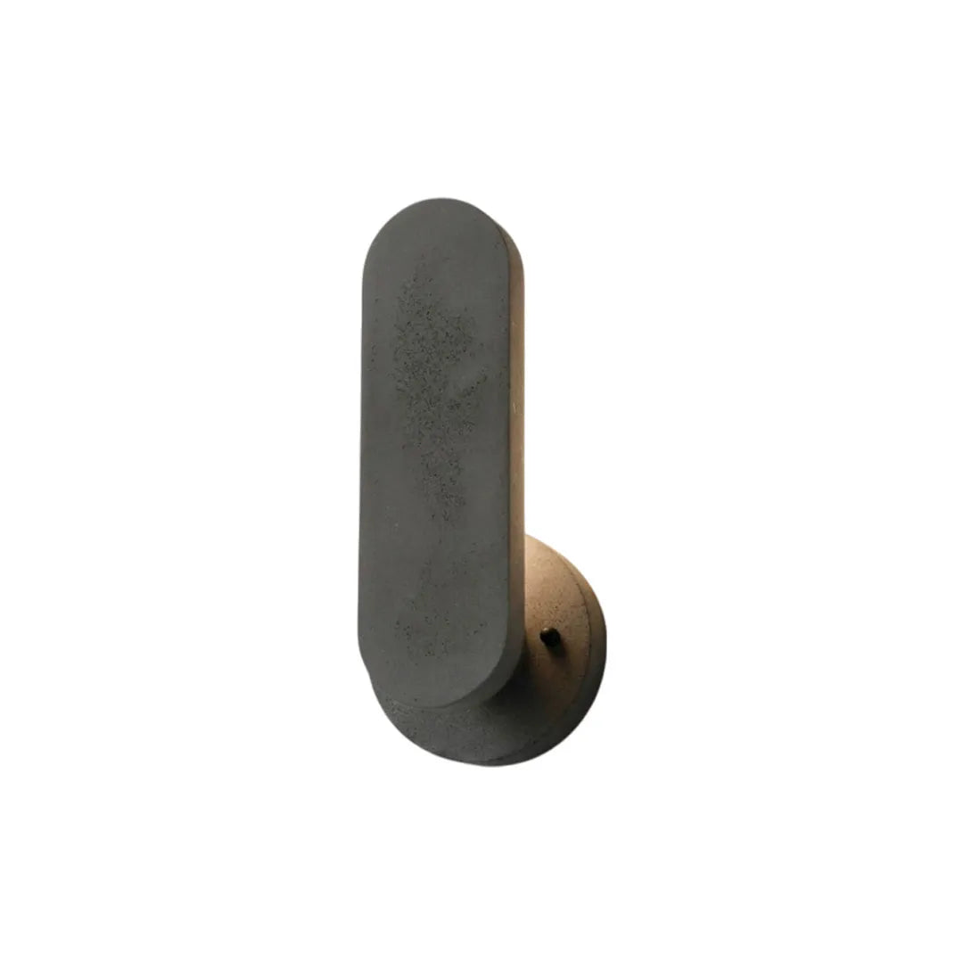 Outdoor modern wall lighting in a matte black finish with a rounded vertical diffuser and circular backplate.