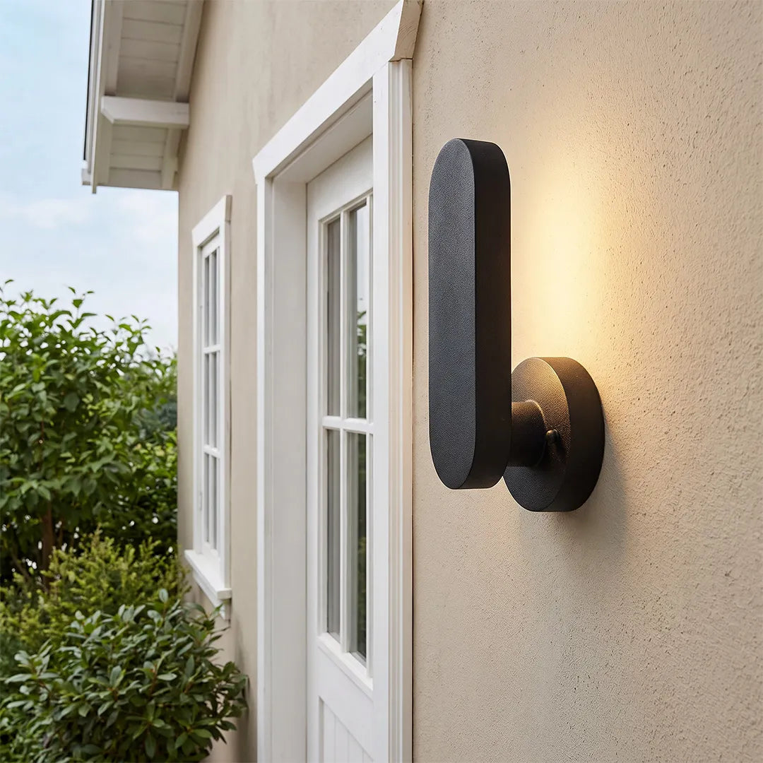 Outdoor modern wall lighting mounted beside a white exterior door on a textured stucco wall.