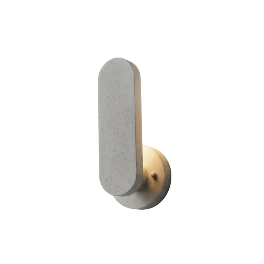 Outdoor modern wall lighting in a light stone finish with a rounded vertical diffuser and warm glow.