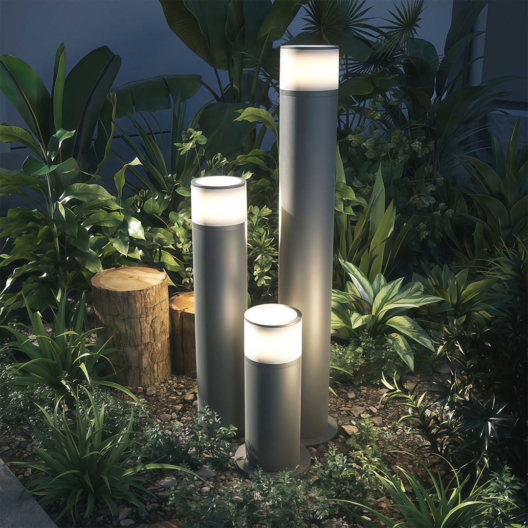 Outdoor path light in a garden with plants, adding a contemporary touch to the outdoor space.