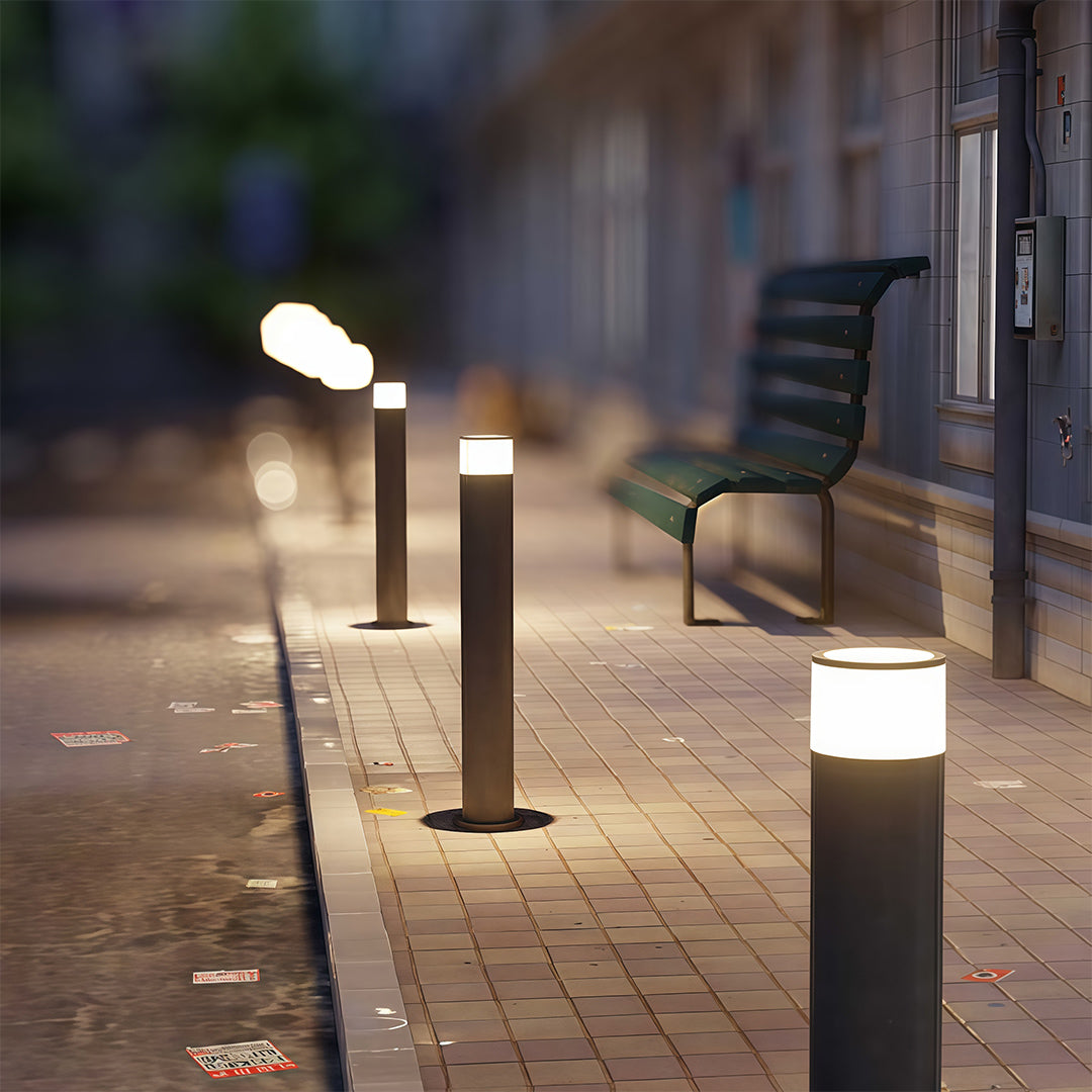 Outdoor path light along a paved walkway, offering stylish and functional lighting.
