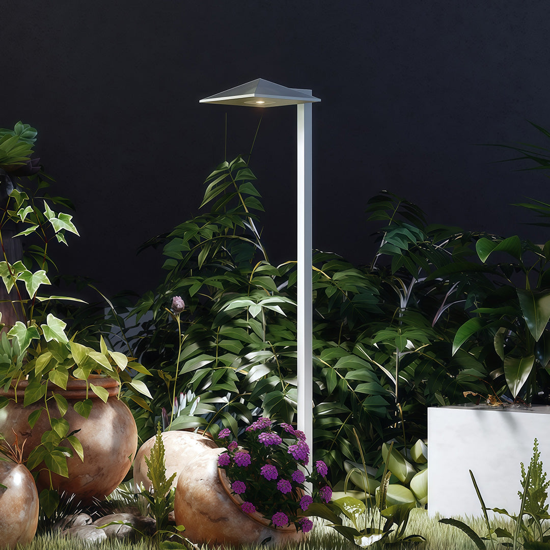 Outdoor pathway light along a garden pathway with decorative plants, offering stylish and functional lighting.