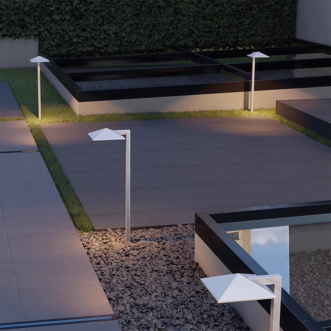 Outdoor pathway light placed near a paved walkway, enhancing the outdoor ambiance with subtle lighting.