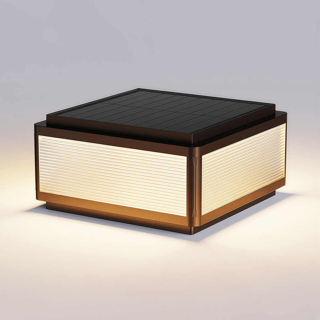 Outdoor patio pillar light installed near a railing by a pond, providing warm and inviting illumination.