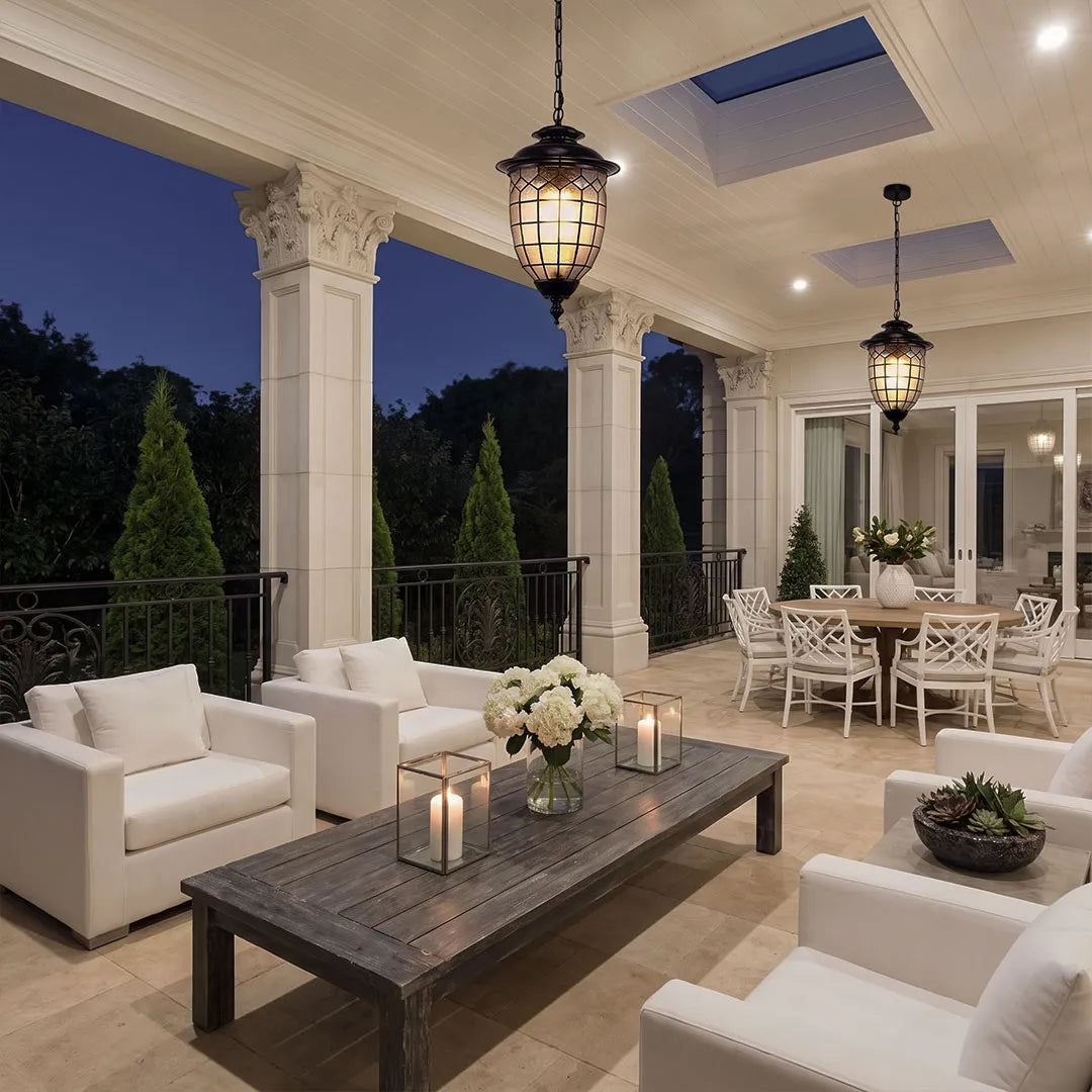 Outdoor pendant lighting fixtures installed along a spacious covered patio with white columns and lounge seating.