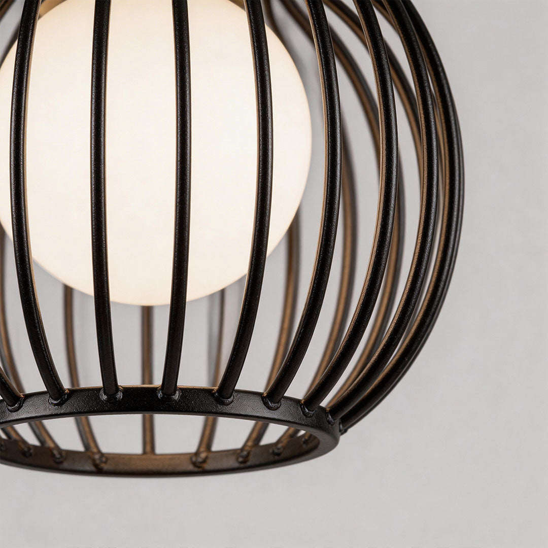 Outdoor pendant lighting modern with a black metal cage design, hanging above a table.
