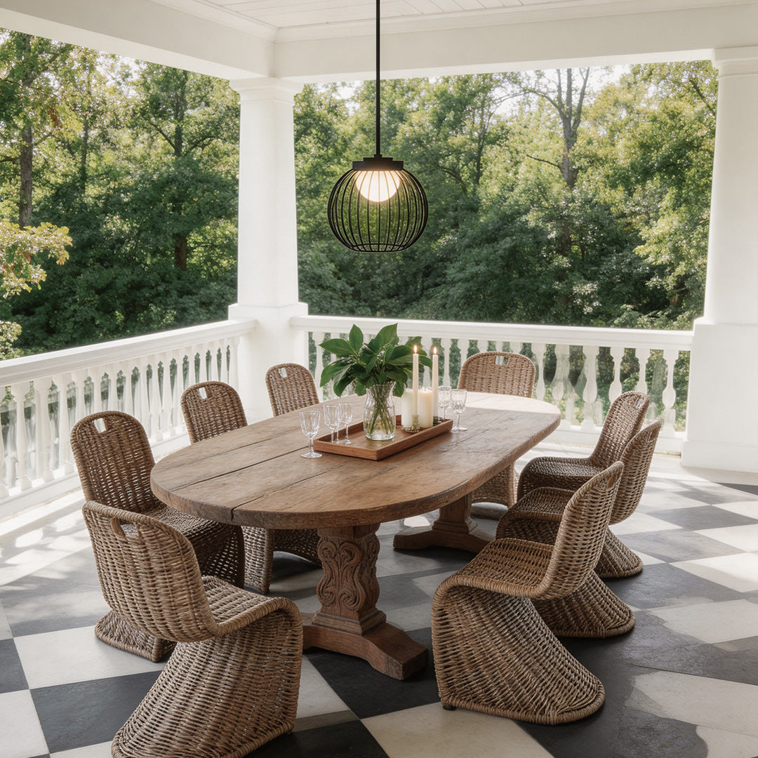 Outdoor pendant lighting modern with a black metal cage design, enhancing a dining area.