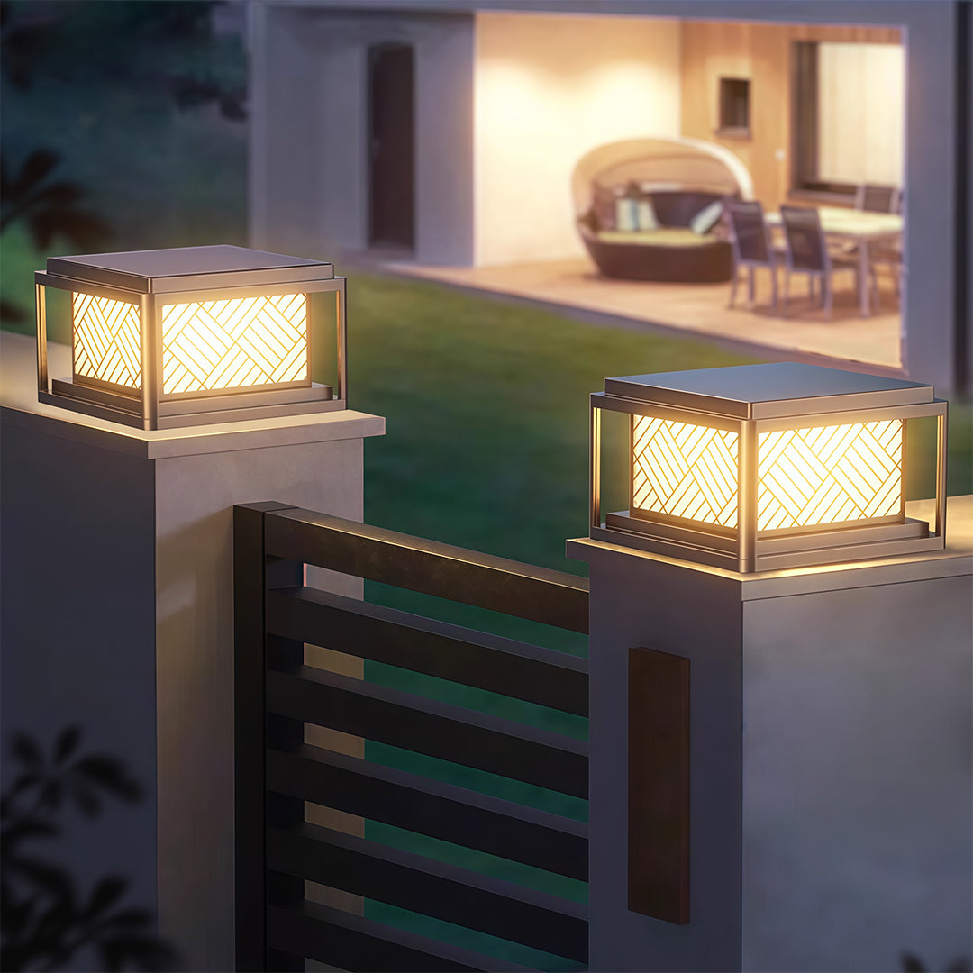 Pair of outdoor pillar LED lights illuminating a modern gate entrance at night.