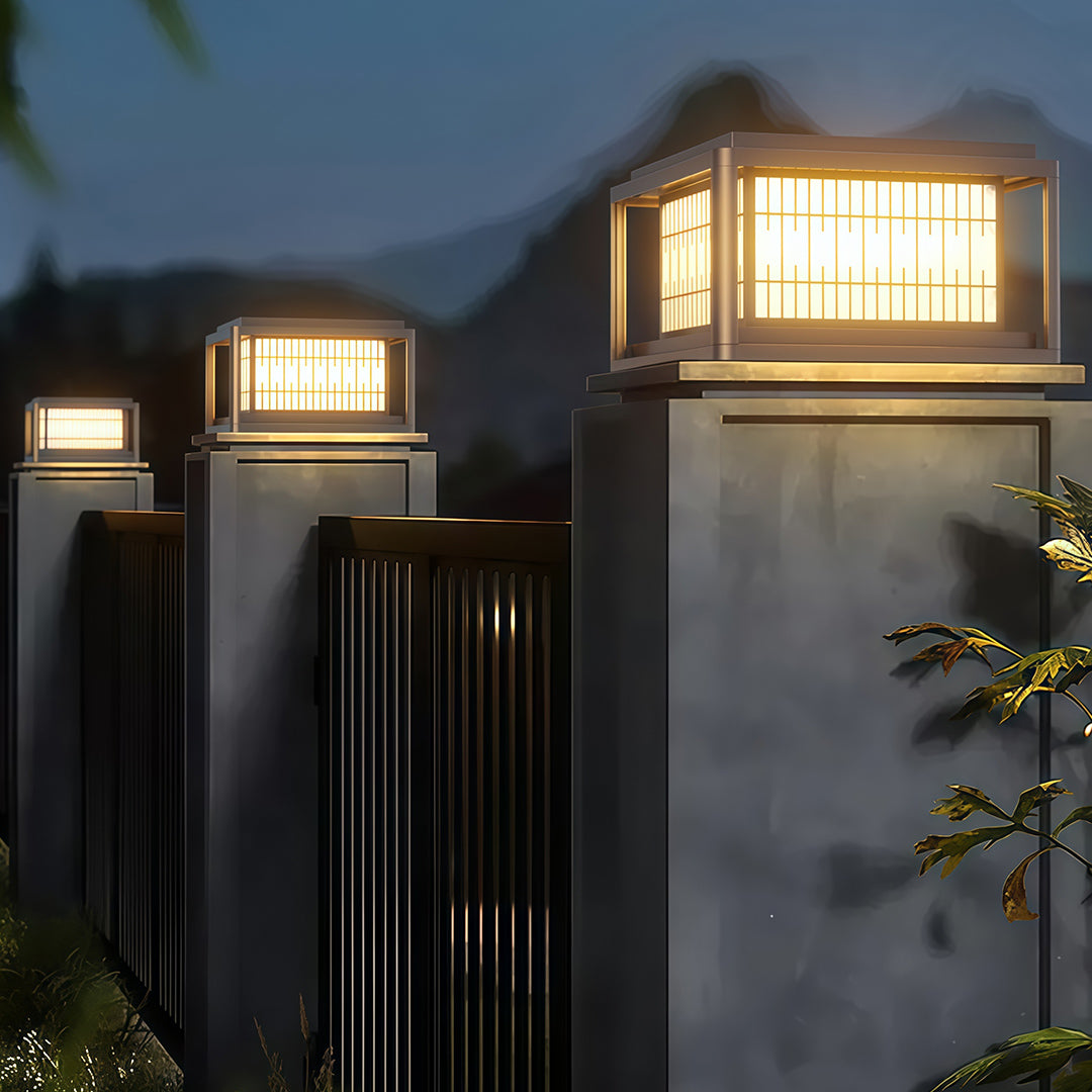 Outdoor pillar LED lights mounted on modern grey columns illuminating contemporary entrance at dusk.