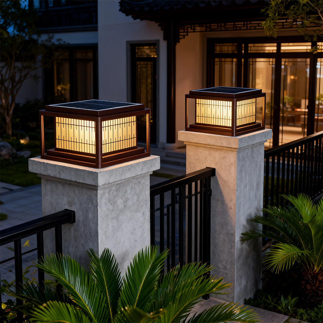 Outdoor pillar LED lights positioned on stone posts near modern architecture with dark wood siding.