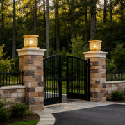 Luxury outdoor pillar lights solar installed on stone gate columns with warm ambient lighting at dusk.
