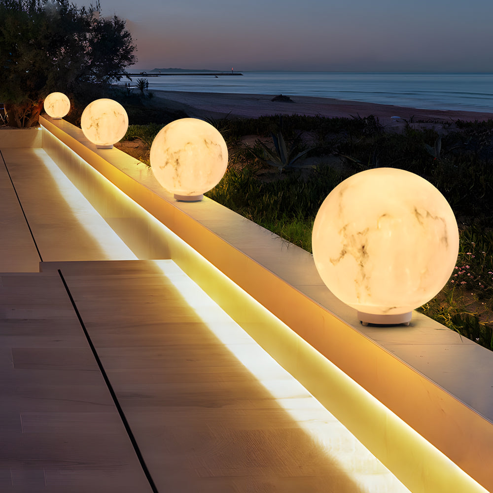 Outdoor pillar lights lining a wooden deck, providing subtle and sophisticated lighting for outdoor spaces.