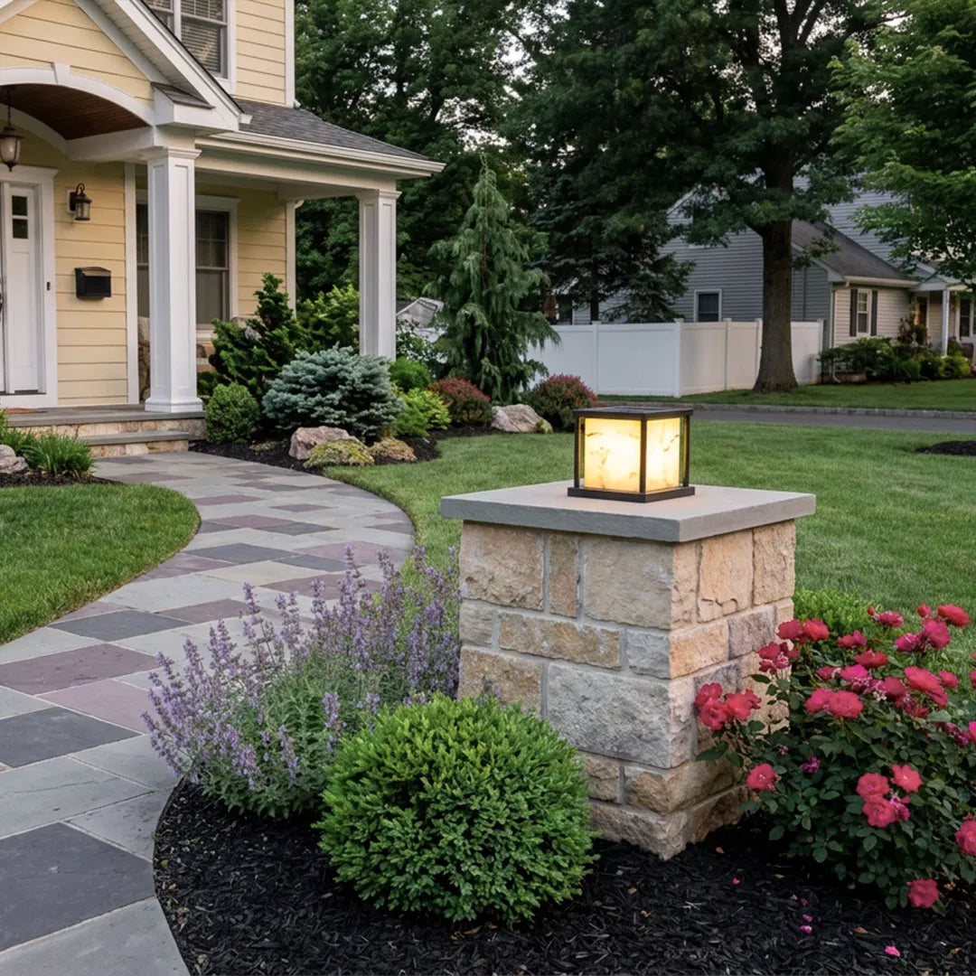 Outdoor pillar solar lights mounted on stone columns along a residential garden walkway.