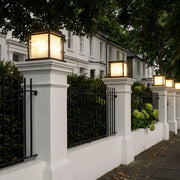 Outdoor pillar solar lights installed on entrance gate pillars with warm landscape lighting.