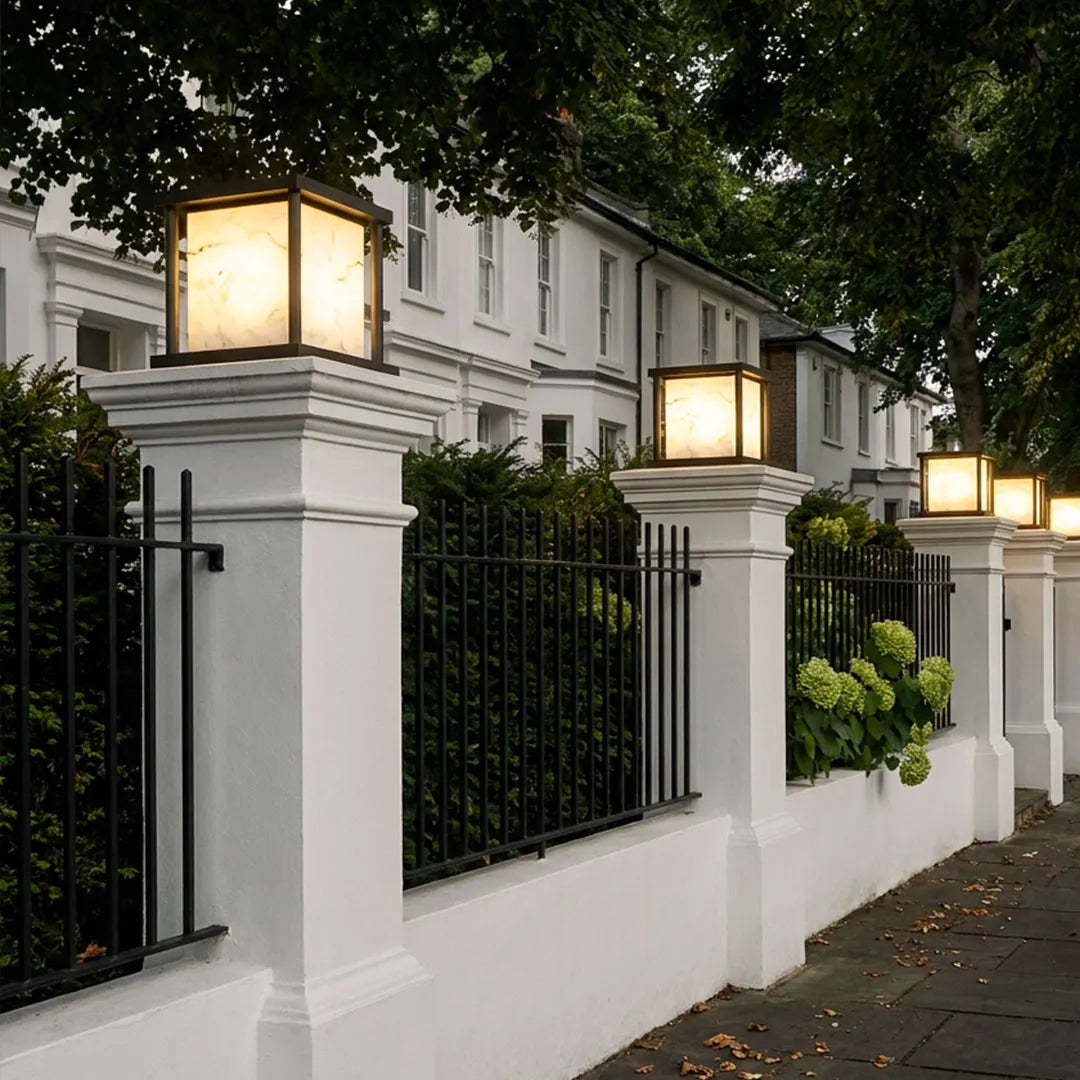 Outdoor pillar solar lights installed on entrance gate pillars with warm landscape lighting.