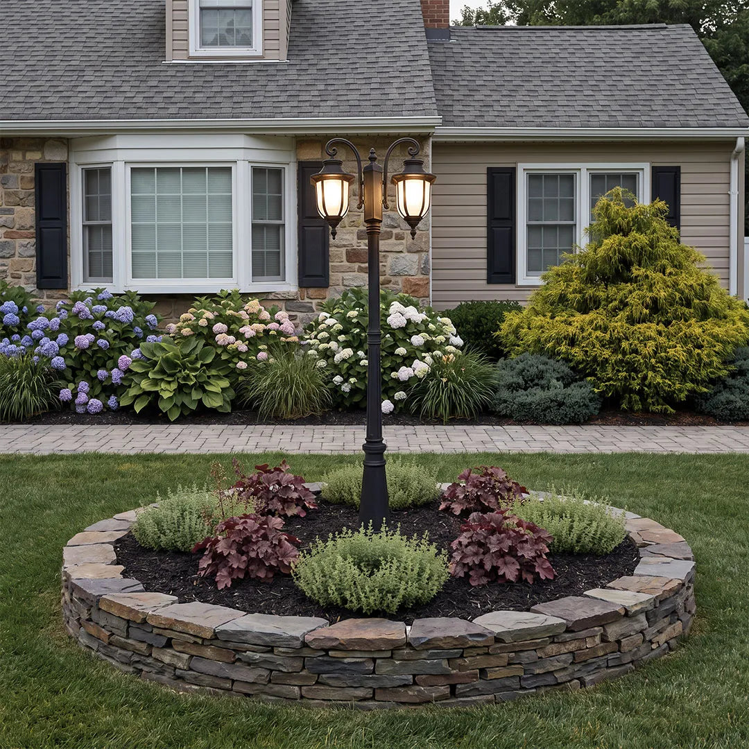 Outdoor post light fixture installed in a circular garden bed in front of a suburban home.