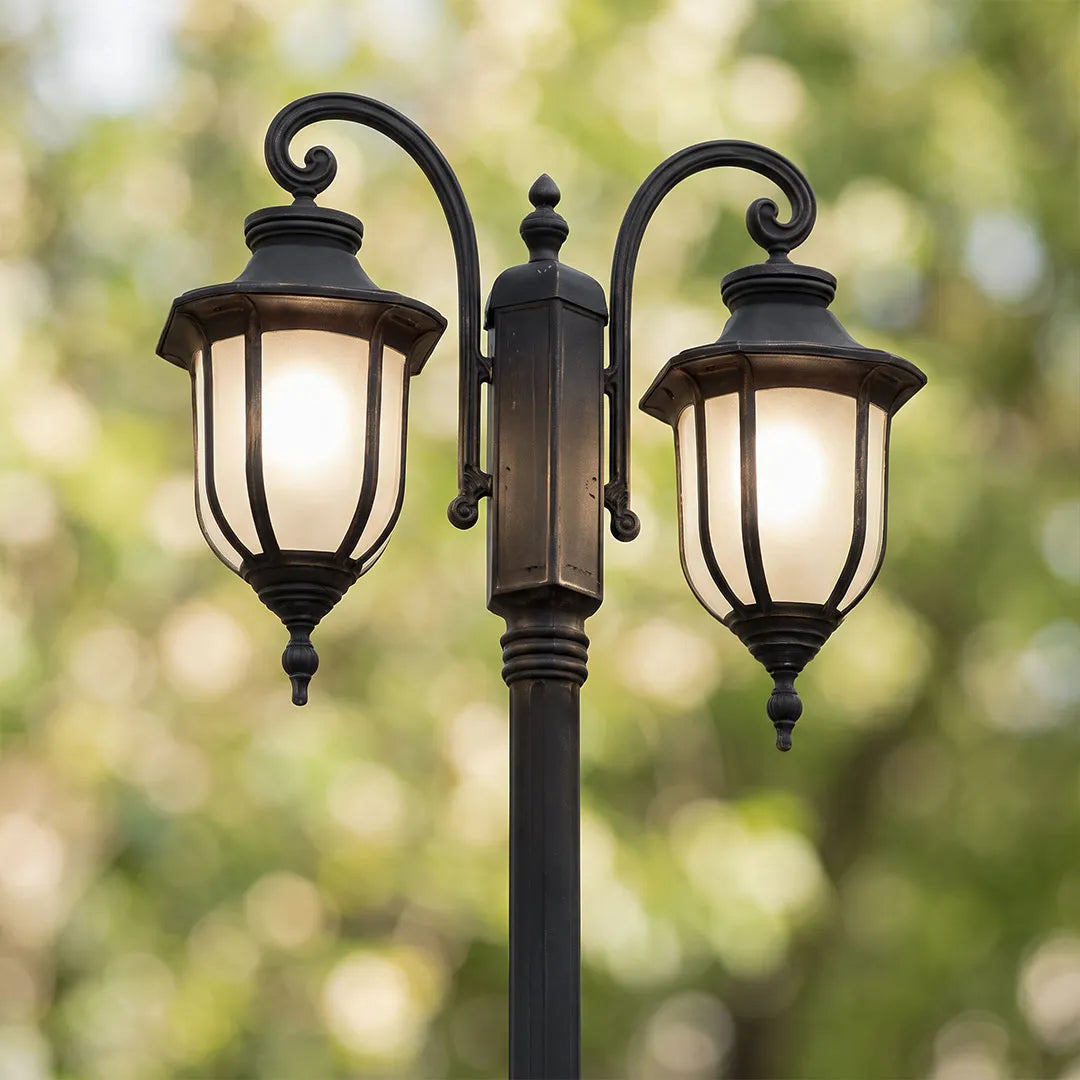 Outdoor post light fixture close-up featuring twin lantern heads and a black decorative pole.