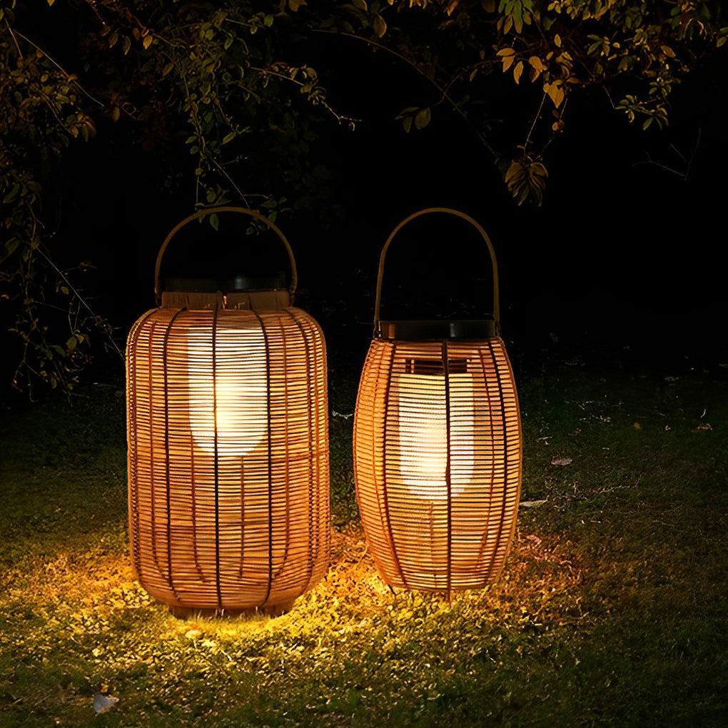 Outdoor rattan lanterns placed on grass with warm light.