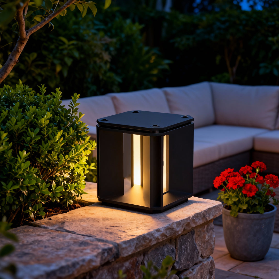 Outdoor landscape scene featuring black cube main gate pillar light design illuminating garden pathways.