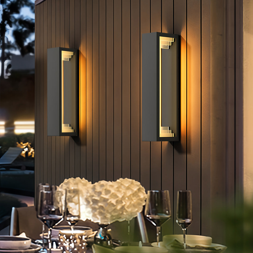 Outdoor sconce modern wall lights installed beside patio doors, illuminating an outdoor dining space warmly.