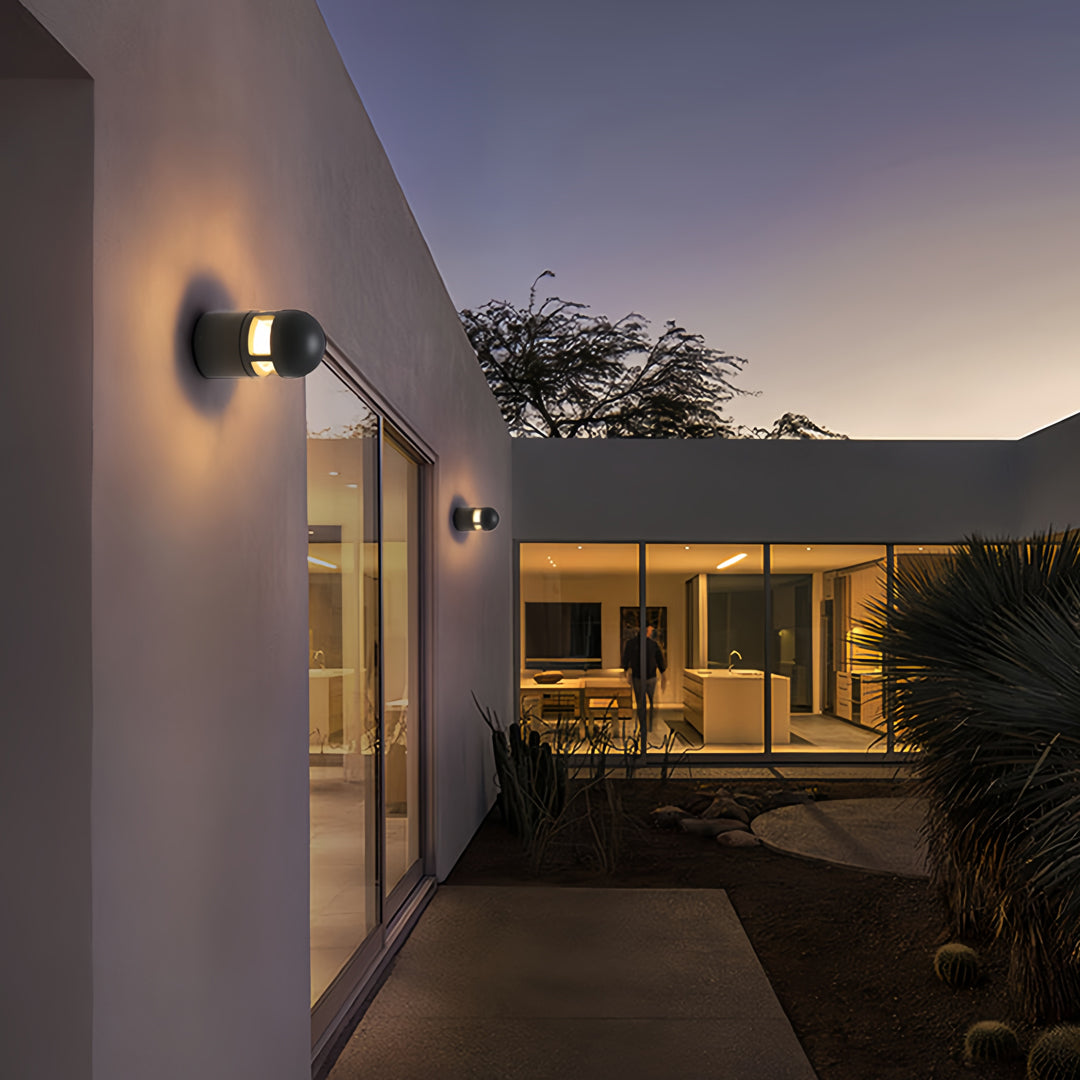 Contemporary wall-mounted outdoor sconces lights installed on a white exterior wall at dusk.
