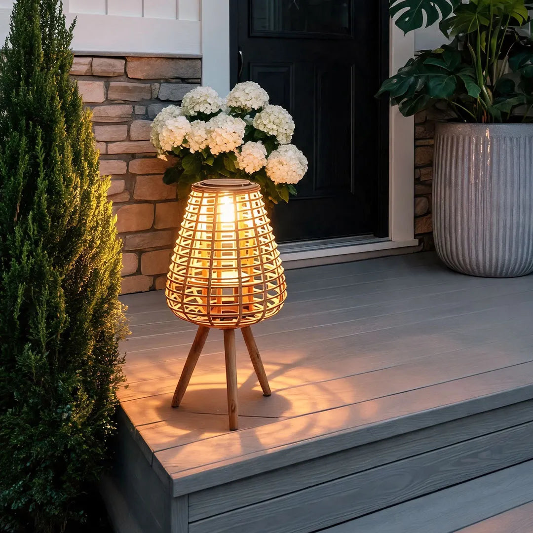 Outdoor solar floor lamps arranged beside a front entrance with a natural woven shade and warm glow.